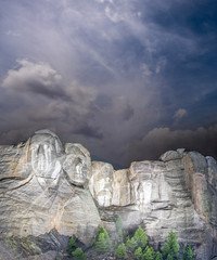 Mt. Rushmore national memorial park in South Dakota at night, presidents faces illuminated against...