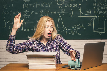 Blonde woman in front of chalkboard. Education and campus people concept. Teenage students with school notebook. Student sitting at desks in classroom and demonstrating bad behavior.