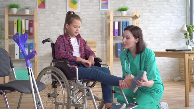 Teenage girl after an injury in a wheelchair at the reception of a doctor
