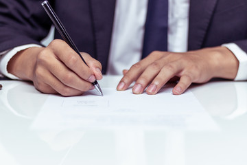 Businessman signing a document in office