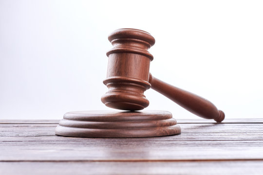 Wooden Gavel Over White Background. Jude Gavel On Brown Wooden Table. Law, Justice And Auction.