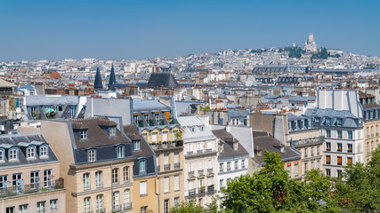 Fototapeta na wymiar Paris, panorama of the city, typical roofs and buildings, with Montmartre and the Sacre-Choeur basilica in background