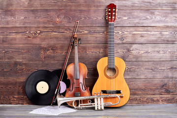Retro musical instruments on wooden background. Acoustic guitar, trumpet, violin, vinyl records and...