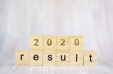 The word result and 2020 on wooden cube block. 2020 result concept