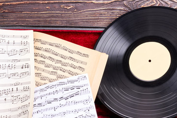 Vinyl record and musical notes close up. Gramophone record and musical notes sheets. Retro music art.