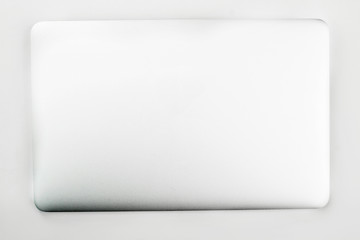 Closed laptop over white background. Silver laptop isolated on white. Modern portable technology concept.