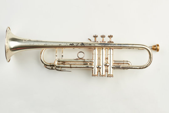 Rusty trumpet on white background. Old classical trumpet. Vintage musical instrument.