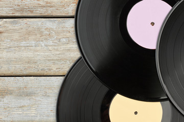 Vinyl records on wooden background. Close up set of gramophone records on wooden boards, cropped image.