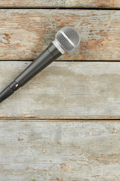 Microphone on old wooden background. Microphone on wooden planks and copy space, vertical image.