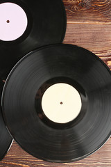 Obraz premium Vinyl records background, top view. Vinyl plates on brown wooden surface, vertical image.