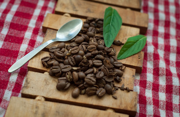Coffee beans on wood table.Coffee with green leaves