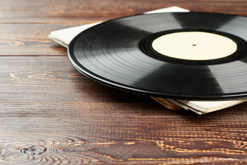 Vinyl record on wooden background. Vinyl LP disc on brown wooden table and copy space. Vintage...