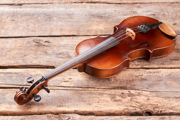 Fototapeta na wymiar Old violin on wooden floor. Classical stringed instrument of orchestra. Baroque style instrument.