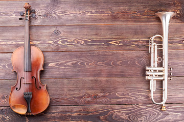 Violin, trumpet and copy space. Musical instruments of orchestra on textured wooden background with text space. © DenisProduction.com
