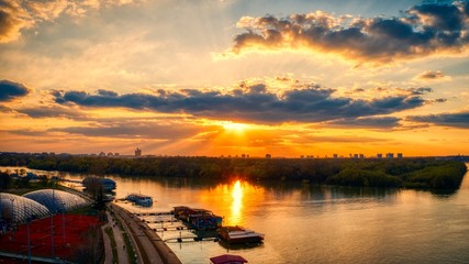 Beautiful sunset with a dock visible next to Sava river in Belgrade, with an island visible in the center