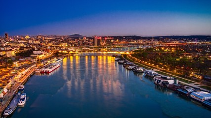 Fototapeta na wymiar Belgrade on the river with boats and buildings at night with reflection and the night sky