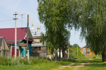 wilde russische Dorfstraße mit Kirche im Hintergrund
