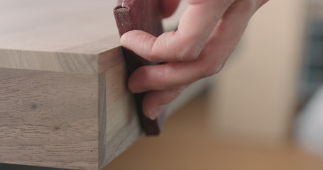 woodworker hand sanding black walnut drawer tray