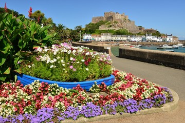 Jersey, U.K. July 28th 2019, 12th century Grouville landmark Mont Orguiel castle and harbour with a promenade of park gardens. © alagz