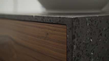 Closeup black walnut drawer in terrazzo cabinet