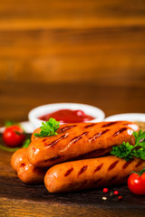 Grilled Smoked Hot Dogs Sausages on Wooden Background. Selective focus.