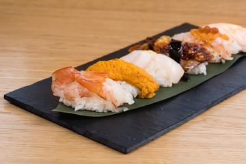 Fototapeta na wymiar different varieties of nigiri, Pacific Sea Urchin, steamed salmon, steamed shrimp, caviar, roasted eel and squid