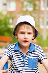 Portrait of a little blonde boy in a blue hat
