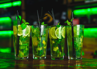Tall glasses with a mojito cocktail on the bar counter