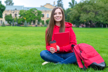 Close up photo of cheerful excited teen teenager hipster holding takeaway mug with tea  and copybook