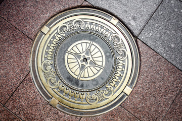 Exclusive manhole cover on the road. Beautiful design of the manhole cover.