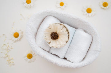 Decor for the Spa. White towels wrapped in a straw and aroma flowers neatly stacked in a top view basket