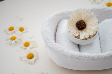 Three white towels are folded into a straw and decorated with flowers on a white background.