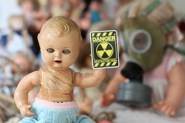 Scary doll showing radioactivity sign 