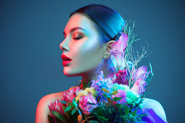 Sexy brunette model girl with bouquet of beautiful flowers. Beauty young woman with bunch of...