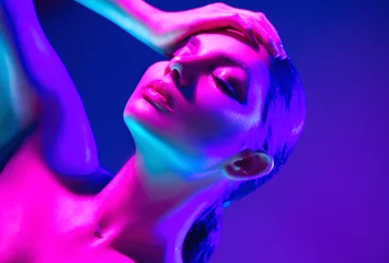 Schilderijen op glas Mannequin vrouw in kleurrijke felle neonlichten poseren in studio. Portret van mooie sexy dansende meisje in UV. Art design kleurrijke make-up © Subbotina Anna