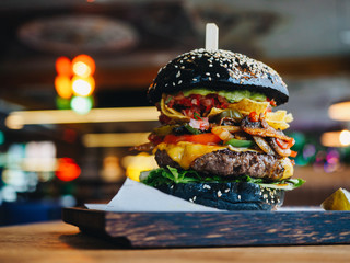 Big burger with beef cutlet, black bun and mushrooms