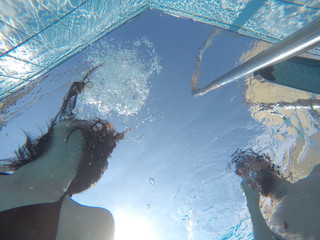 guy with a girl swimming in the pool at the hotel in summer