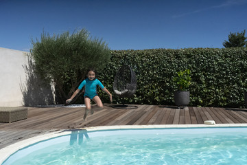 Fille de 7 ans sautant dans la piscine