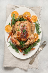 Traditional roasted turkey with rosemary on light table. Top view.