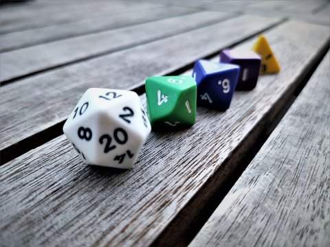 Perspectiva de una fila de dados con diferentes n&uacute;meros colocados sobre una mesa de madera