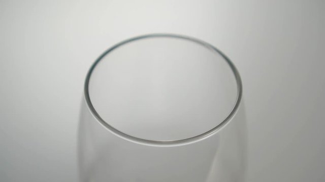 Drops of liquid fall into an empty glass beaker