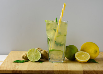 Cooling lemonade with lemon and lime, slices of ginger and mint leaves.
