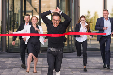 Business people crossing red finish line