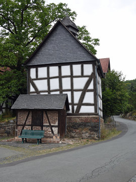 Small chapel and tiny building with bench in half-timbered architecture in Bellnhausen, Germany