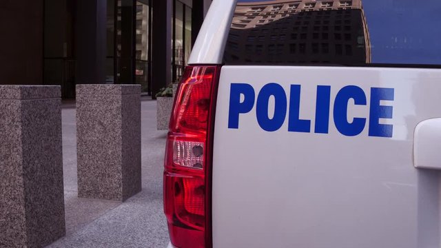Police vehicle parked in front of professional office building.