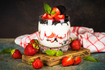 Strawberry dessert parfait with yogurt and chocolate cookies.