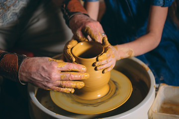 Pottery workshop. Grandpa teaches granddaughter pottery. Clay modeling