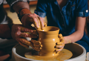 Pottery workshop. Grandpa teaches granddaughter pottery. Clay modeling