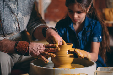Pottery workshop. Grandpa teaches granddaughter pottery. Clay modeling