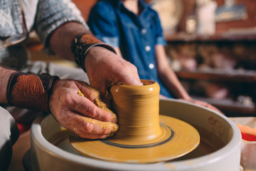 Pottery workshop. Grandpa teaches granddaughter pottery. Clay modeling